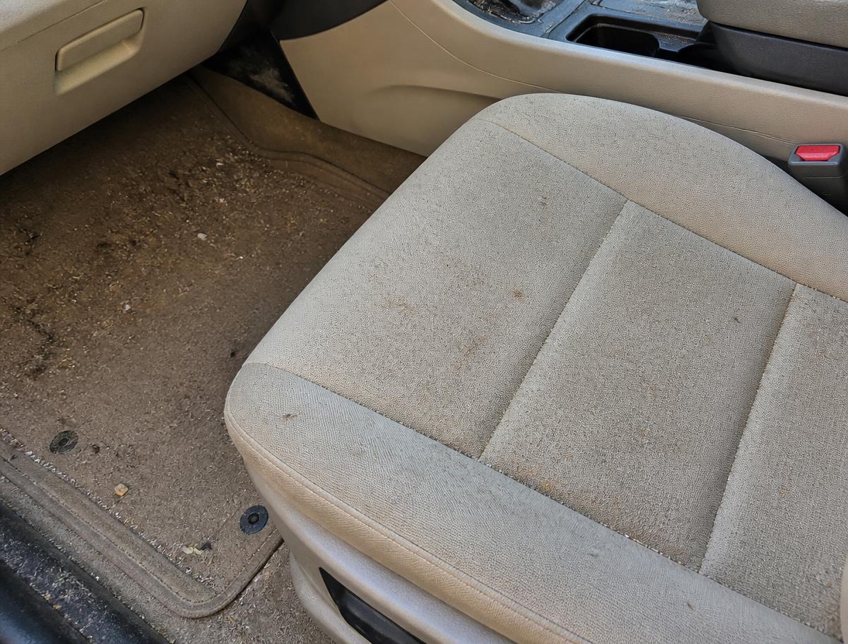 Car seat and floor covered in crumbs and dirt before cleaning